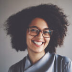 woman with Afro hair in a gray blouse