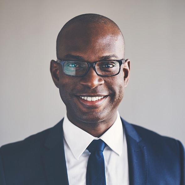 man wearing a dark suit, white shirt, and tie