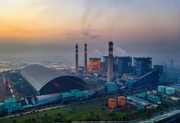 aerial view of an industrial plant with smokestacks at dusk